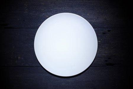 Empty White plate isolated on wood background, Top view, Low key