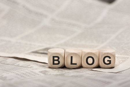 wooden cubes on newspaper forming word BLOGの写真素材