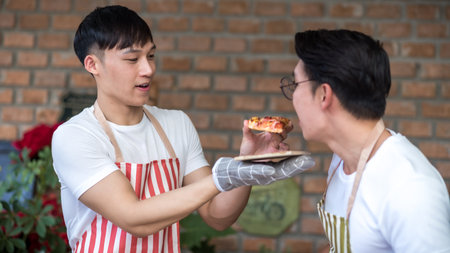 Young asian men couple friend cooking pizza food in the kitchen at home for holiday festival celebration.. LGBT, Gay, Lifestyle and love relationship conceptの写真素材