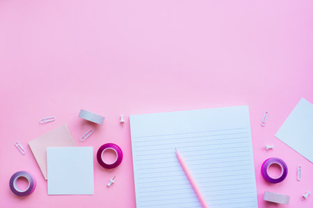Beautiful office stationery flatlay with ruled notebook, white pen, sticky notes, paper clip and...