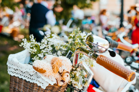Beautiful sping white flowers in a wicker bicycle basket decorated with retro style lace and toy.の写真素材