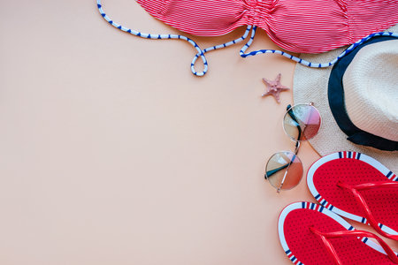 Summer fashion flatlay with gradient round sunglasses, straw hat, bright flats and red striped bikini top decorated with starfish. Perfect beach set for holidays on the sea. Marina style.の写真素材