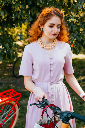 Kiev, Ukraine - May 12, 2018: Girl in pink color vintage dress participating in bicycle tweed run Retro cruise on May 12, 2018 in Kiev, Ukraine.のeditorial素材