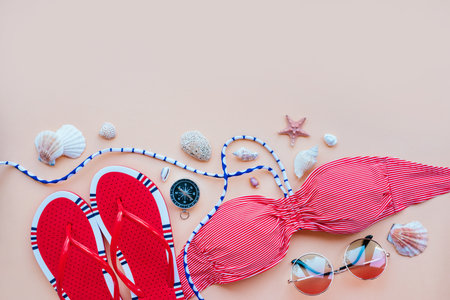 Summer fashion flatlay with gradient round sunglasses, red flats and striped bikini top. Decorated with sea shells and compass. Perfect beach set for holidays on the sea. Marina style.の写真素材