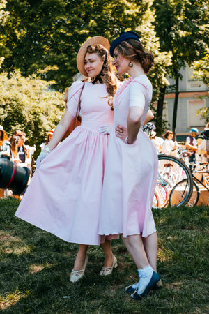 Kiev, Ukraine - May 12, 2018: Two girls in pink vintage dress participating in bicycle tweed run Retro cruise on May 12, 2018 in Kiev, Ukraine.のeditorial素材