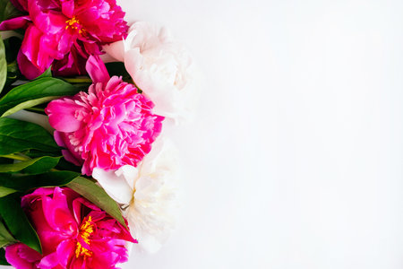 Frame of beautiful fuchsia and white peony flower bouquet on the white background. Closeup, flatlay style.の写真素材