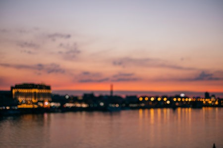 Blurred background of sunset. Cityscape captured on the river.