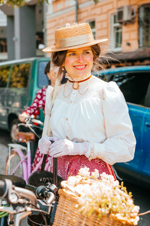 Kiev, Ukraine - May 12, 2018: Girl in vintage blouse, skirt, gloves and straw hat participating in bicycle tweed run Retro cruise on May 12, 2018 acin Kiev, Ukraine.のeditorial素材
