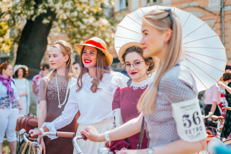 Kiev, Ukraine - May 12, 2018: Young ladies in vintage dresses participating in bicycle tweed run...