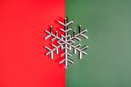 Christmas flatlay with silver snowflake on the bright red and green background.の写真素材