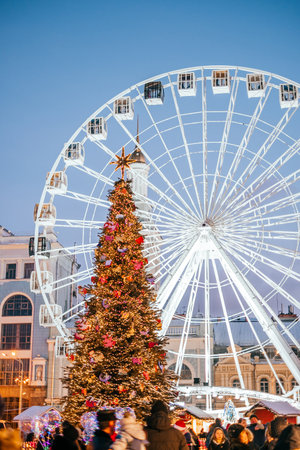 Kyiv, Ukraine - December 25, 2018: Christmas tree on the background of ferris wheel. Christmas fairs in Kyiv with traditional street Xmas market and winter outdoor fun.のeditorial素材