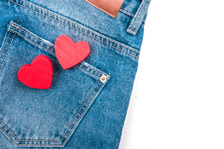 Two small red hearts in jeans pocket on white background.の写真素材