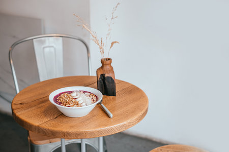 Beautiful blueberry banana smoothie bowl with a spoon on wooden table. Healthy breakfast concept.の写真素材