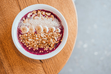 Beautiful blueberry banana smoothie bowl on round wooden table. Healthy breakfast concept.の写真素材