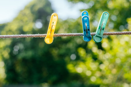 Colorful plastic clothespins on the hangers with blurred background.の写真素材