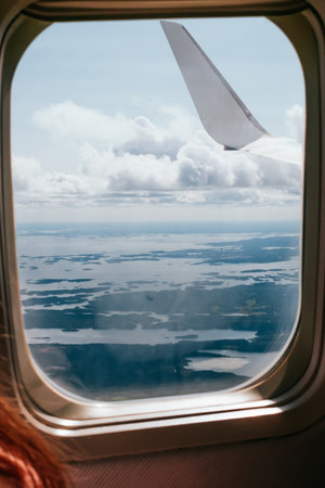 Wing of the airplane with the view of beautiful blue sky and clouds.