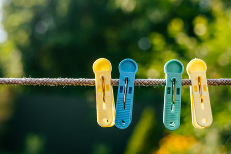 Colorful plastic clothespins on the hangers with blurred background.