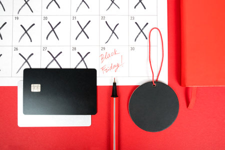 Flat lay with credit cards, price tag, notebook, calendar and highlighter pen isolated on red. Black...