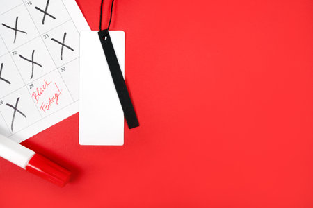 Flat lay with credit price tag, calendar and highlighter pen isolated on red. Black friday concept.の写真素材