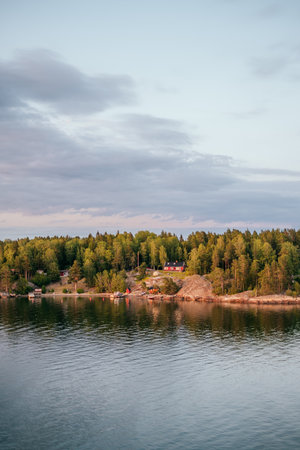 Helsinki, Finland - June 30, 2019: red summer cabin also known as mokki on rocky shore of Turku archipelago in Baltic Sea.のeditorial素材