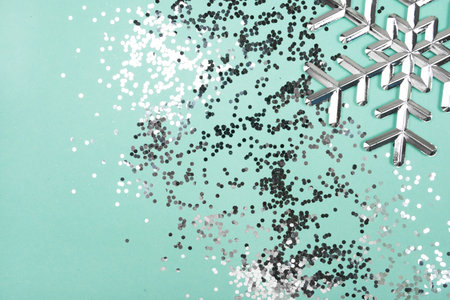 Silver snowflake with glitter isolated on blue background. Christmas holiday concept.の写真素材