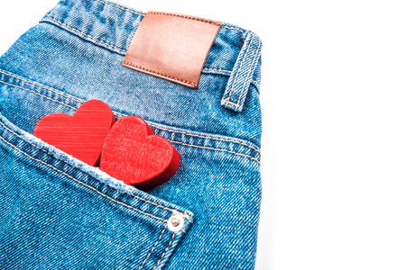 Two small red hearts in jeans pocket isolated on white background.