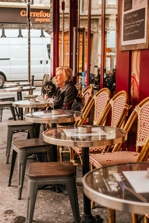 Paris, France - April 6, 2019: Charming traditional french cafe with tables on terrace, landmark in Paris.のeditorial素材