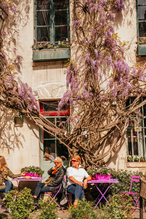 Paris, France - April 6, 2019: Charming traditional french cafe with tables on terrace in evening, landmark in Paris.のeditorial素材