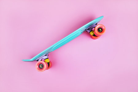 Sport inspired flatlay with turquoise penny skateboard isolated on pink background.の写真素材