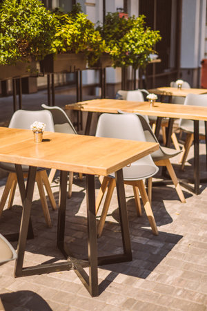 Outdoor cafe terrace with wooden furniture in a sunny day.の写真素材