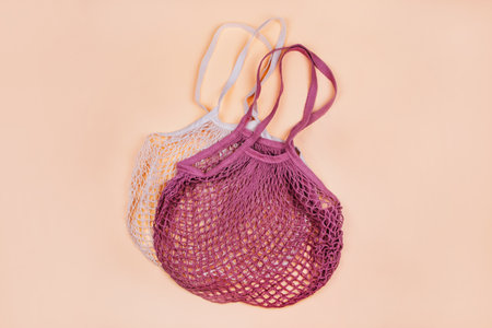 Flatlay with mesh string produce bags isolated on beige background. Zero waste concept.の写真素材