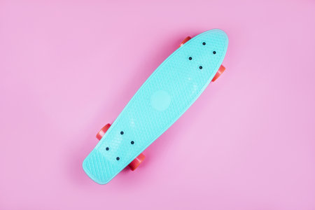Sport inspired flatlay with turquoise penny skateboard isolated on pink background.の写真素材