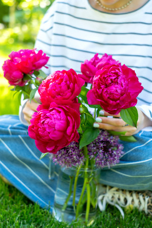 Photo of woman holding beautiful bouquet of pink peony flowers.の写真素材