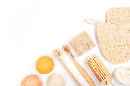 Flatlay with wooden brush, bamboo toothbrushes, bar of soap, konjac and loofahs sponge and cotton earbuds isolated on white background. Zero waste concept.の写真素材