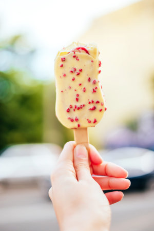 Woman hand holding white chocolate ice cream with berries.の写真素材