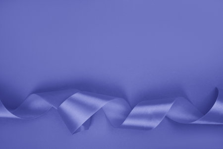 Curly shiny ribbon isolated on violet background.の写真素材