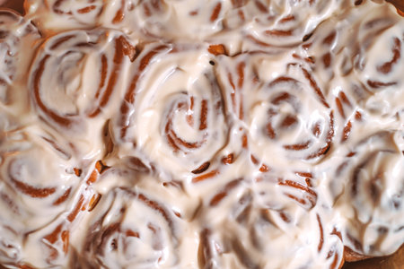 Cosy Christmas background made with cinnamon rolls with icing.の写真素材