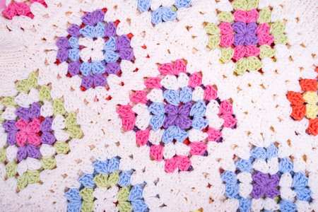 Closeup background of multicolored granny square crochet knitting.の写真素材