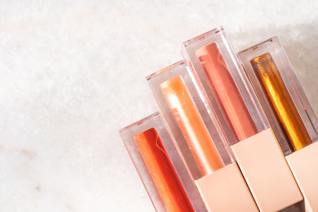 Four shades of trendy bronze lip gloss on a marble background.の写真素材