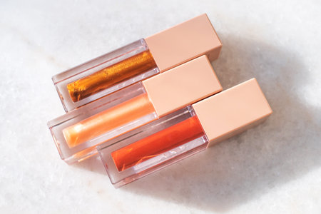 Three shades of trendy bronze lip gloss on a marble background.の写真素材