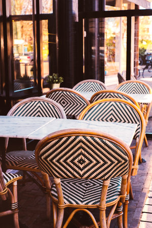 Wicker chairs and round table with flowers on the terrace of the street cafe.の写真素材