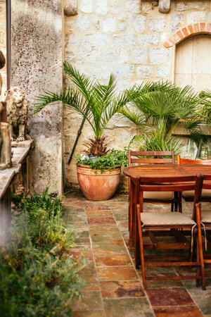 Beautiful patio with wooden furniture and plants in the old cottage.の写真素材
