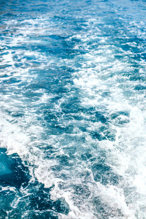 Background of bright turquoise blue water surface with waves.の写真素材