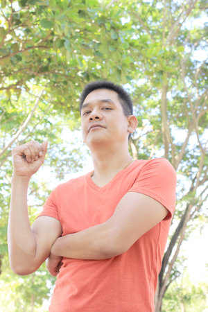 Man standing arms crossed in the gardenの写真素材
