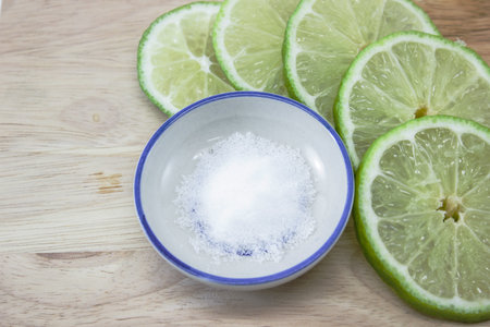 lime slices and salt on wooden plate