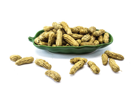peanuts on ceramic plate isolated on white backgroundの写真素材