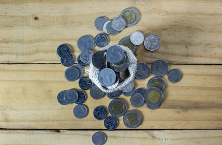 Overflow money very much from bag on wood ground from top view. Conceptual saving money become millionaire.の写真素材