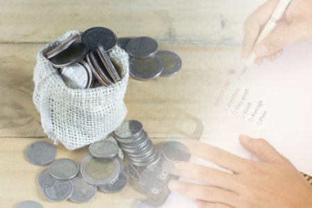 Overflow money very much from bag on wood ground. Hand checking quality. Conceptual saving money...