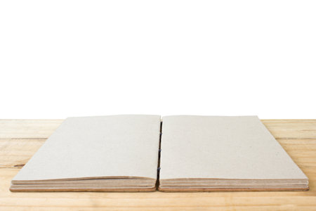 Open hand made book on table isolated on white background.