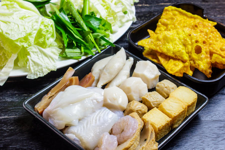 Shabu set ready to eat on wood table. Vegetables, dumpling, and shabu set.の写真素材